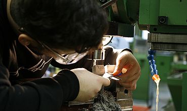 Auszubildender arbeitet im Fachbereich Metalltechnik an einer Maschine